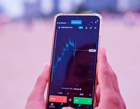 User touching green buy and red sell buttons on a crypto trading application